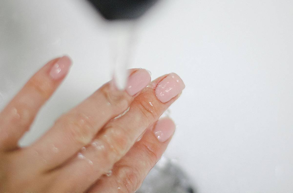Cross-section diagram showing healthy vs damaged nail plate with labeled layers and moisture loss points