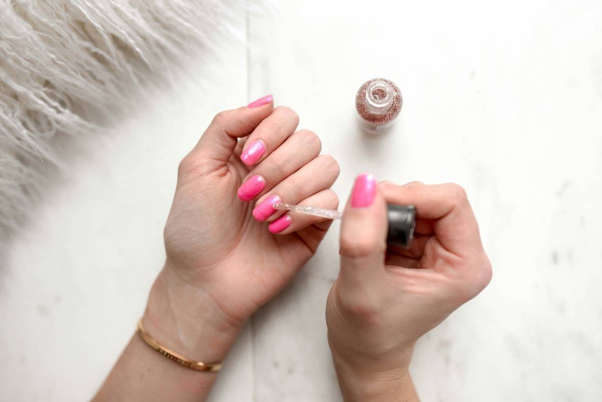 Infographic showing 5 factors affecting nail growth: hydration, nutrition, chemical exposure, mechanical trauma, and underlying health conditions
